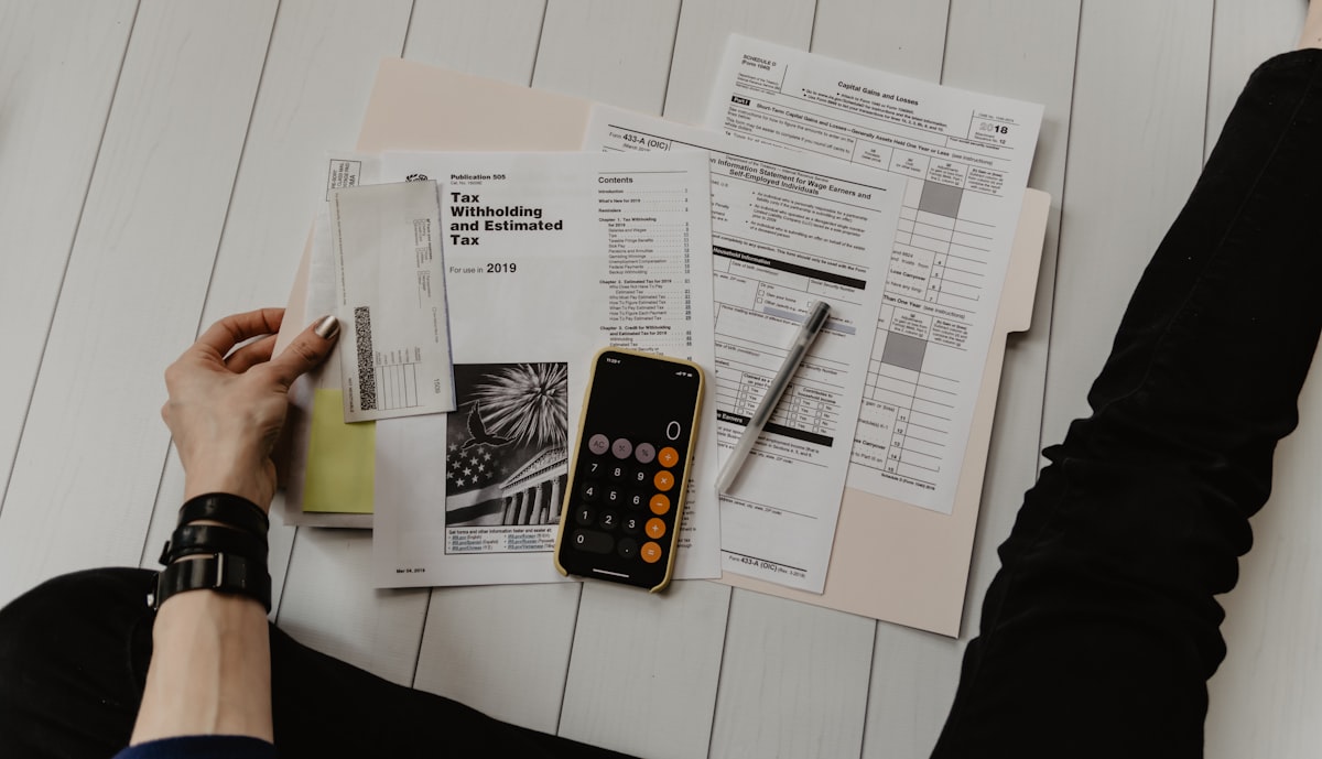 Organized tax paperwork, a notebook and a calculator laid out on a desk