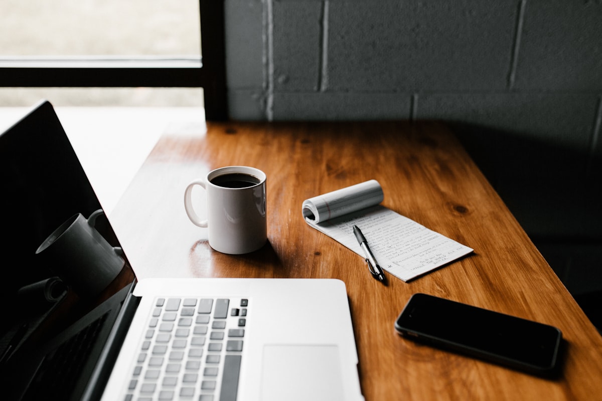 A laptop and notebook set up for a virtual consultation call
