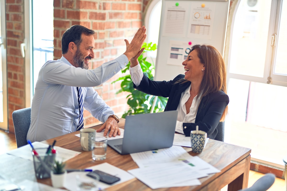 Two professionals reviewing business documents together across a table