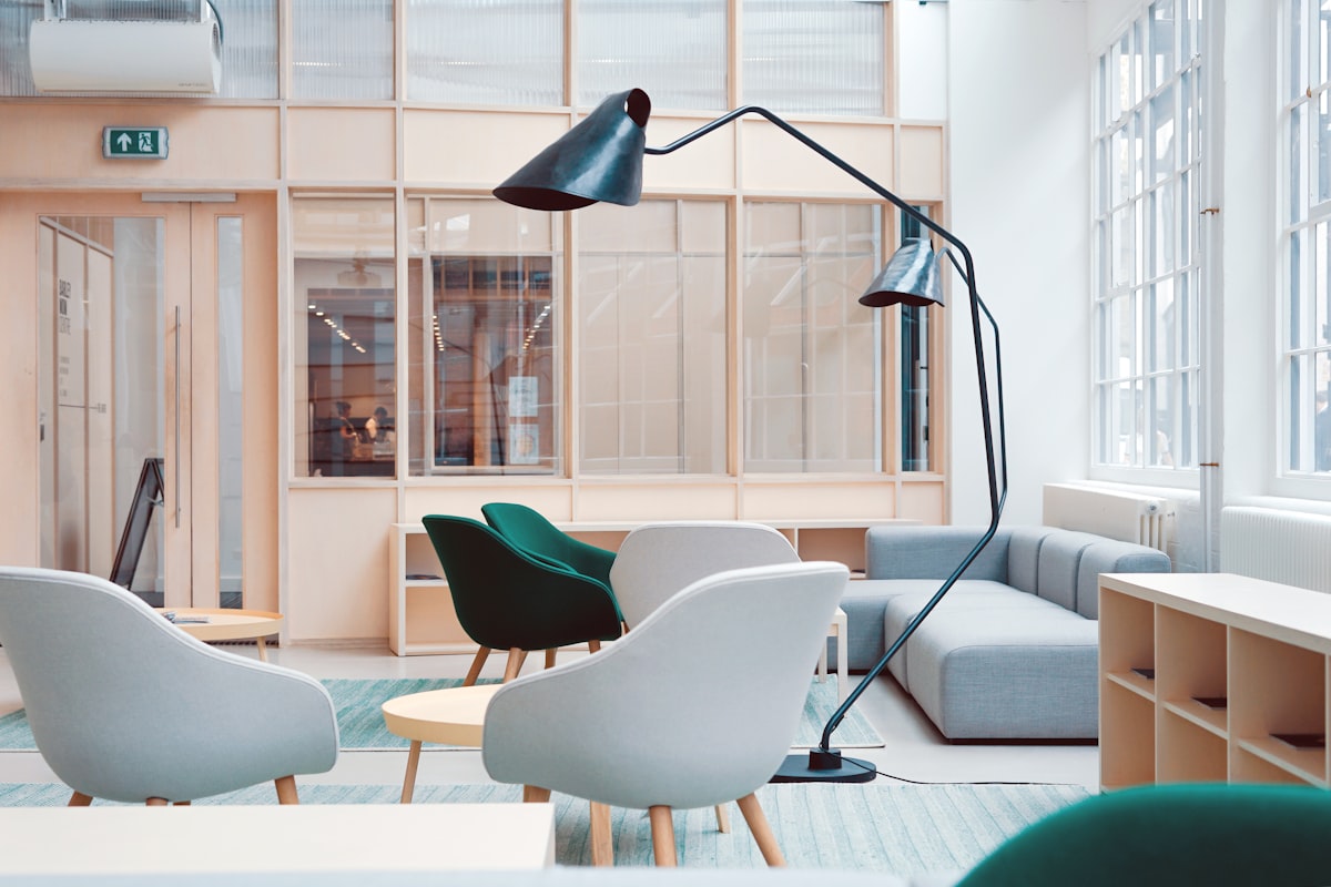 Quiet, light-filled waiting area with soft armchairs and a floor lamp